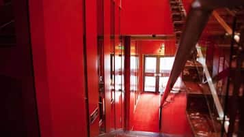 A red corridor with a staircase leading to a higher level.