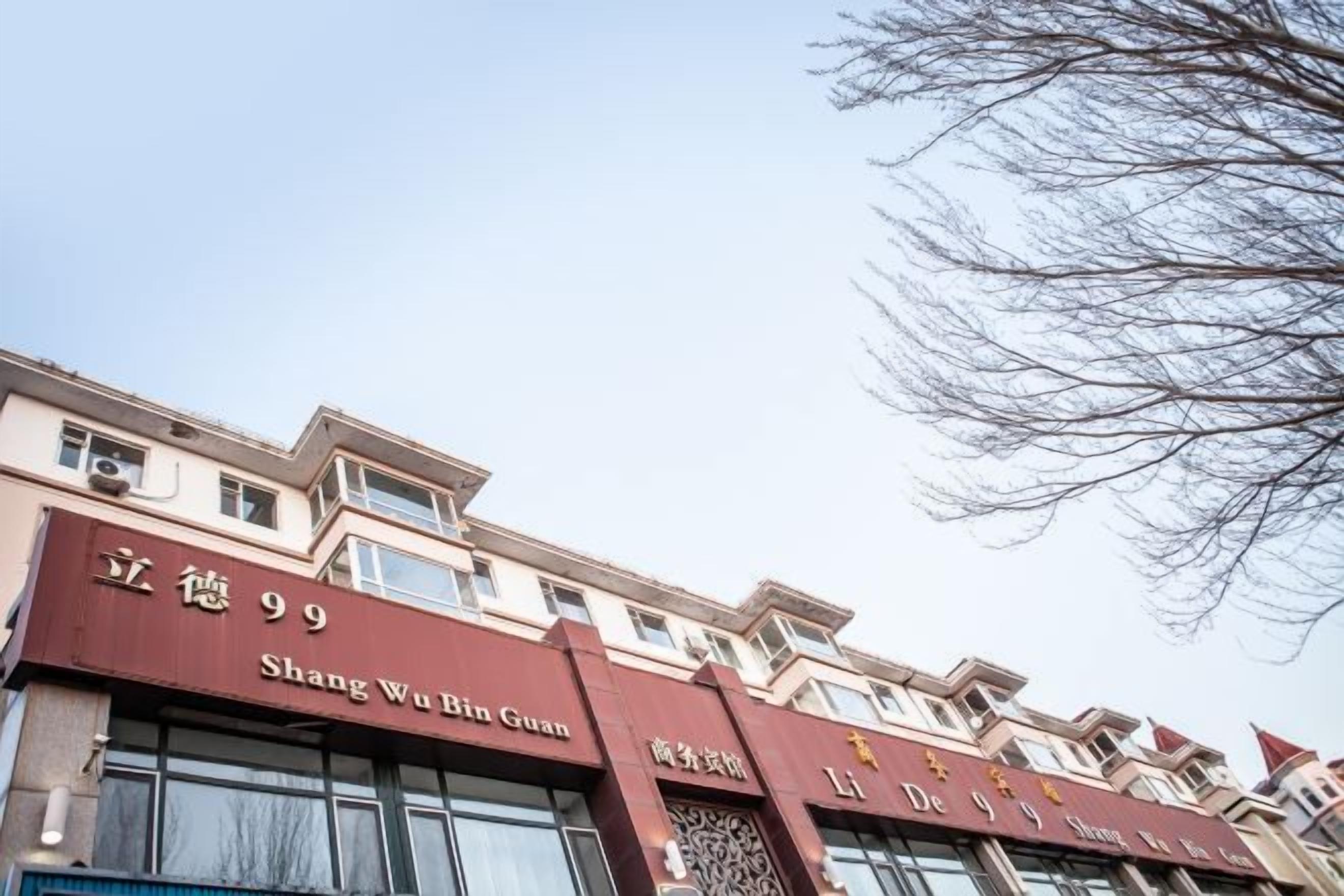 Un edificio con señalización que dice 'Shang Wu Bin Guan' y 'De Jin Hu'.