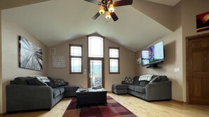 A spacious living room with two grey sofas, a coffee table, a wooden floor, and a ceiling fan. - Deadwood & Sturgis 5 bedroom next to golf course (Sturgis)