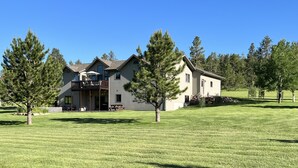 A two-story house with a balcony, surrounded by a well-maintained lawn and trees. - Deadwood & Sturgis 5 bedroom next to golf course (Sturgis)