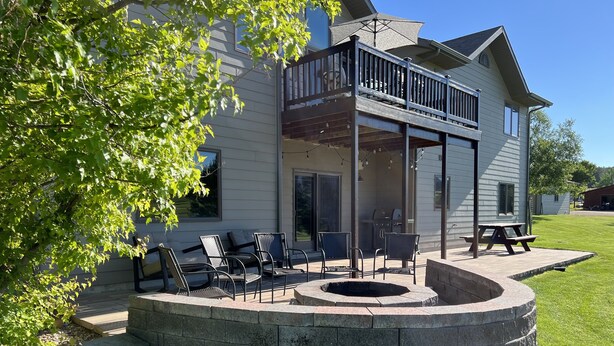 A house with a covered patio, outdoor seating, and a fire pit. - Deadwood & Sturgis 5 bedroom next to golf course (Sturgis)