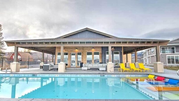A covered outdoor pool area with seating and a view of the surrounding landscape. - The Sandbar #41 - Lake, Pool and Hot Tub Access! (Garden City)