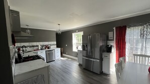 A modern kitchen with a stainless steel refrigerator, a dishwasher, and a gas stove.