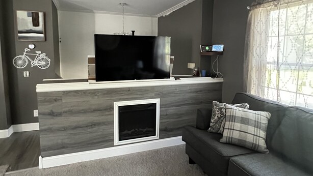 A modern living room with a built-in entertainment unit, a sofa, and a fireplace.