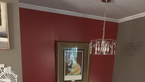 A room with a red accent wall, a framed artwork, and a decorative bicycle.