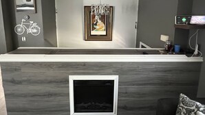 A modern reception area with a marble counter, framed artwork, and a mounted bicycle decoration.