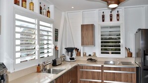 A modern kitchen with white cabinetry, a built-in oven, and a coffee maker.