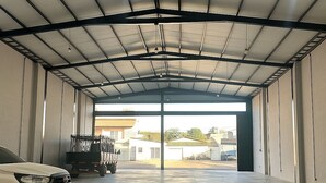 A spacious indoor garage with a white SUV parked inside. - HOTEL SEVEN (Goiânia)