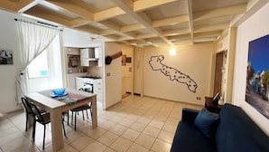Un espacio habitable compacto con comedor, kitchenette y una pared con un mapa.