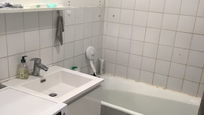 A bathroom with a washing machine, a sink, and a bathtub. - Paris 12th (Paris)