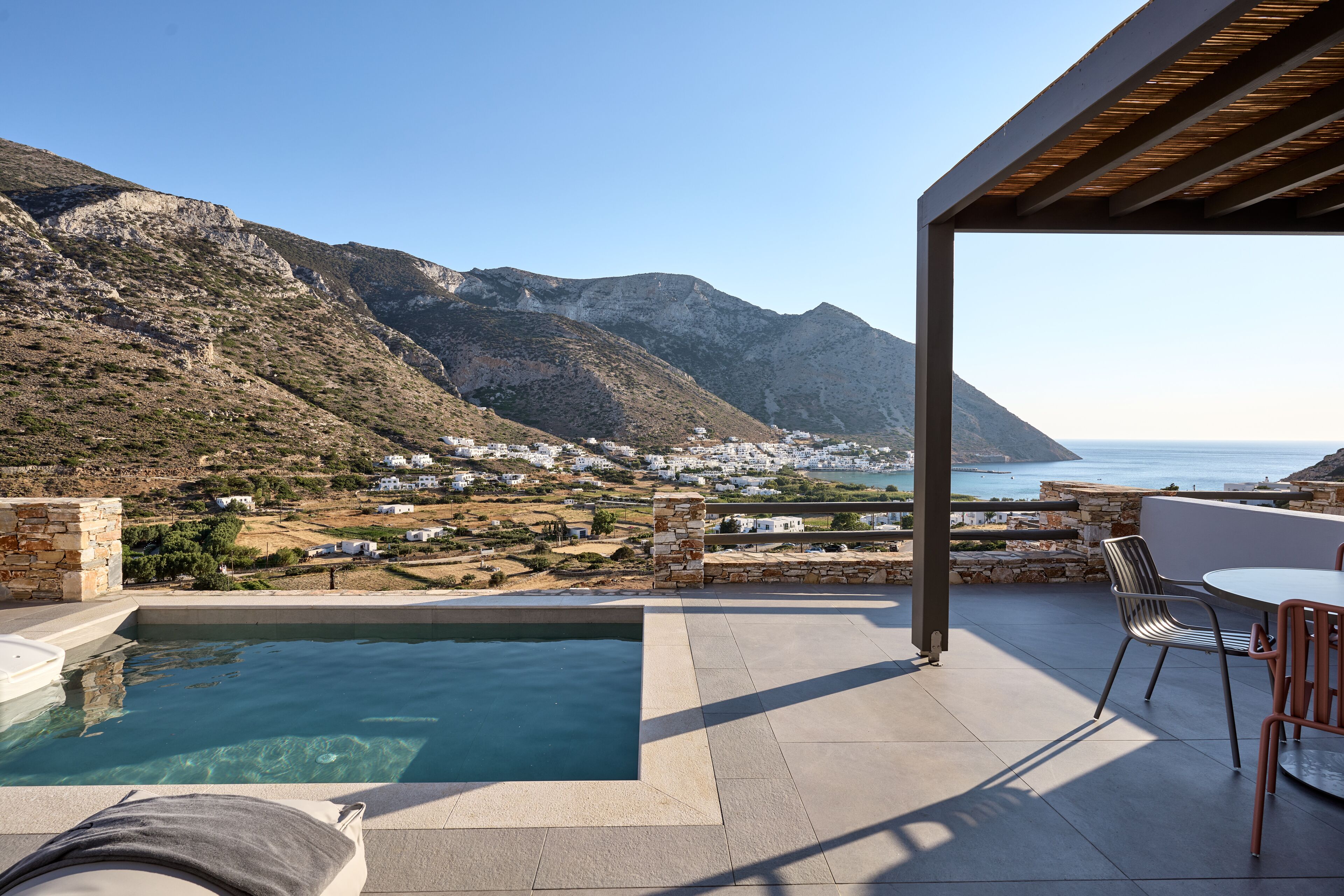 Un área de piscina con vistas al mar y a las montañas.