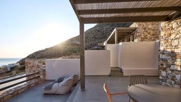 Eine moderne Außenpatio mit einer Steinmauer, einer gepolsterten Sitzgruppe und einem Tisch.