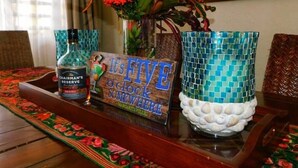 A table with a bottle of Chairman's Reserve whiskey, a clock, and a mosaic vase. - La Kayé Celesté your home away from home!! (Castries)