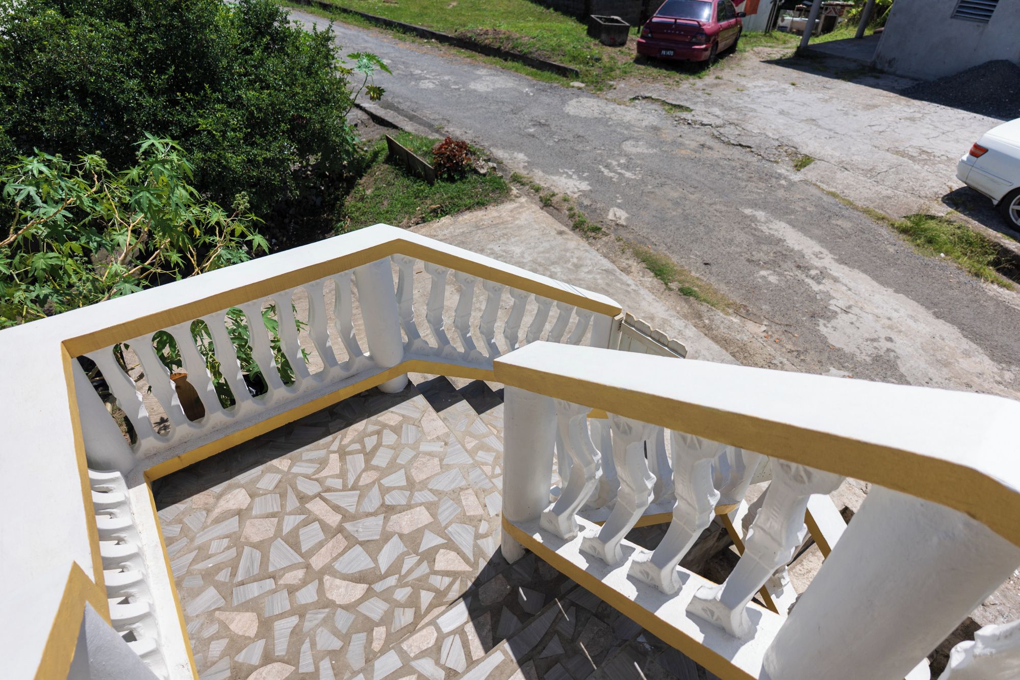 A balcony with a white railing and a patterned floor.