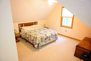 A bedroom with a bed, nightstands, a lamp, a window, and a dresser.