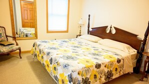 Une chambre à coucher avec un lit, une chaise, une fenêtre et une porte.