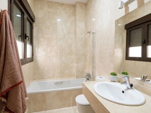 Een bad, een haardroger, handdoeken, zeep