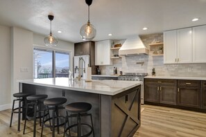 A modern kitchen with a central island, bar stools, stainless steel appliances, and pendant lighting. - Prescott Retreat - views & minutes to Whiskey Row (Prescott)