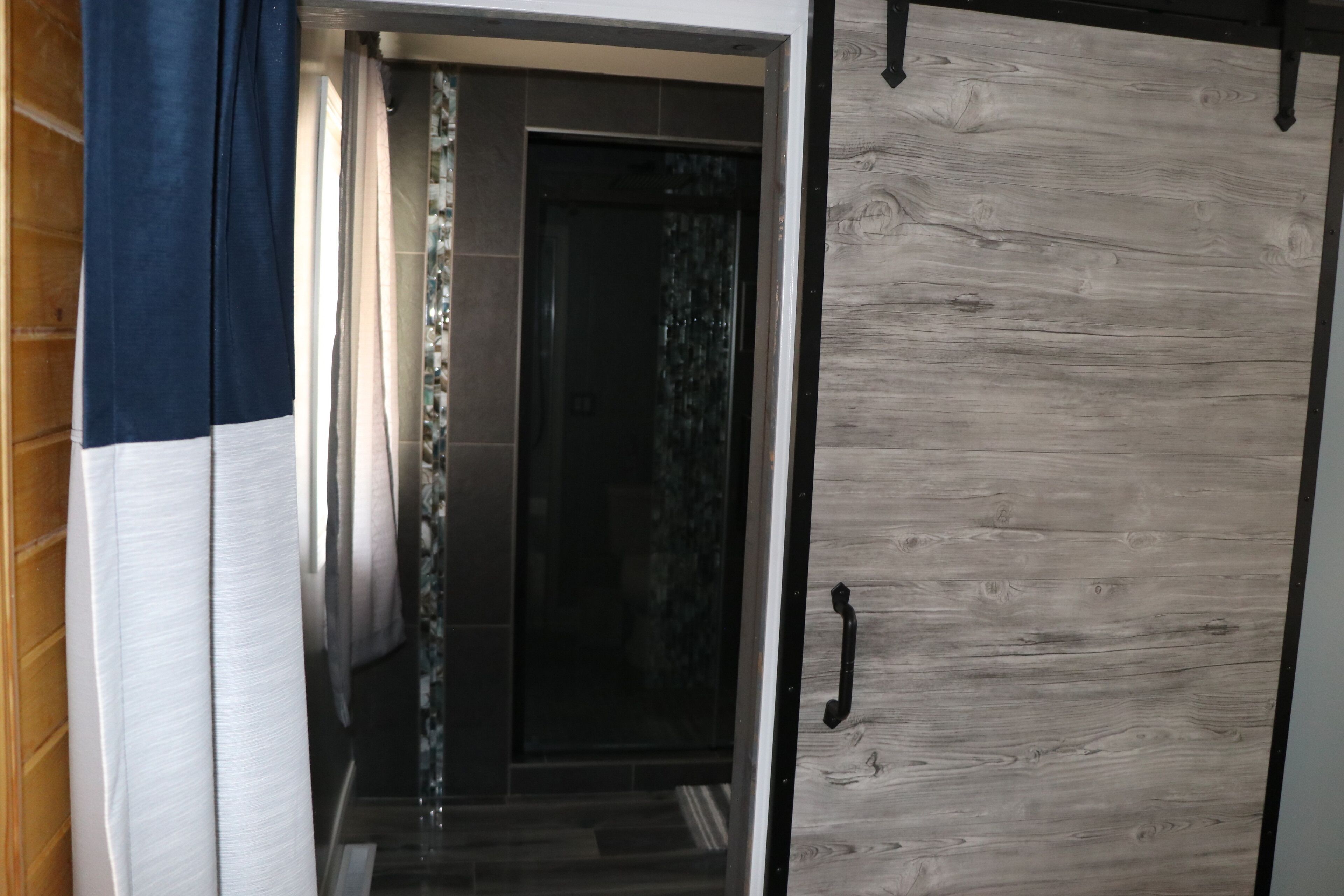 A hallway with a wooden door and a glass door.