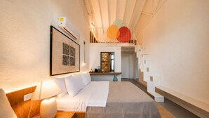 A modern hotel room with a bed, bedside table, lamp, artwork, and a staircase with a unique design. -  Voger Alaçatı Social (Cesme)