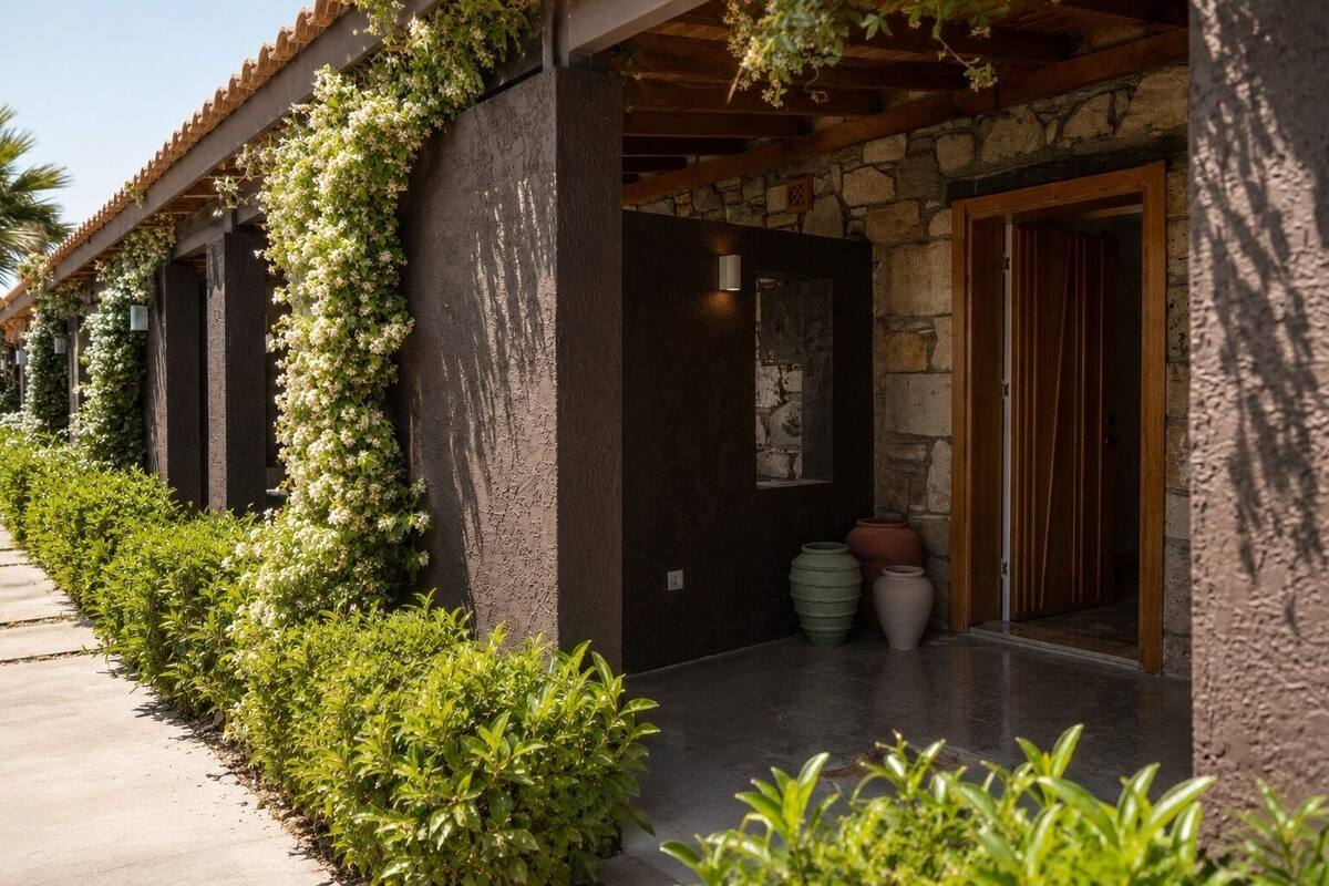 Un edificio con fachada de piedra, un porche cubierto y una puerta con marco de madera.