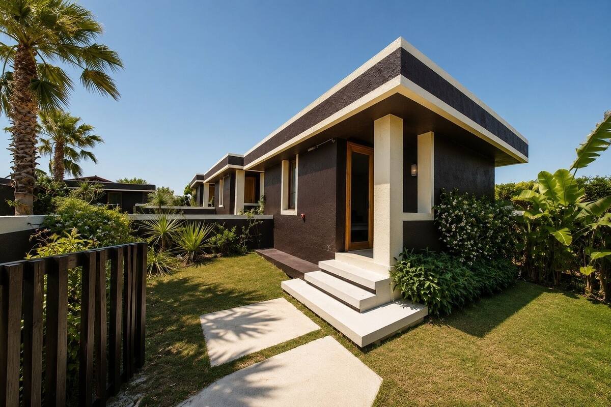 Una casa moderna de dos pisos con techo plano, un porche delantero y un jardín bien cuidado.