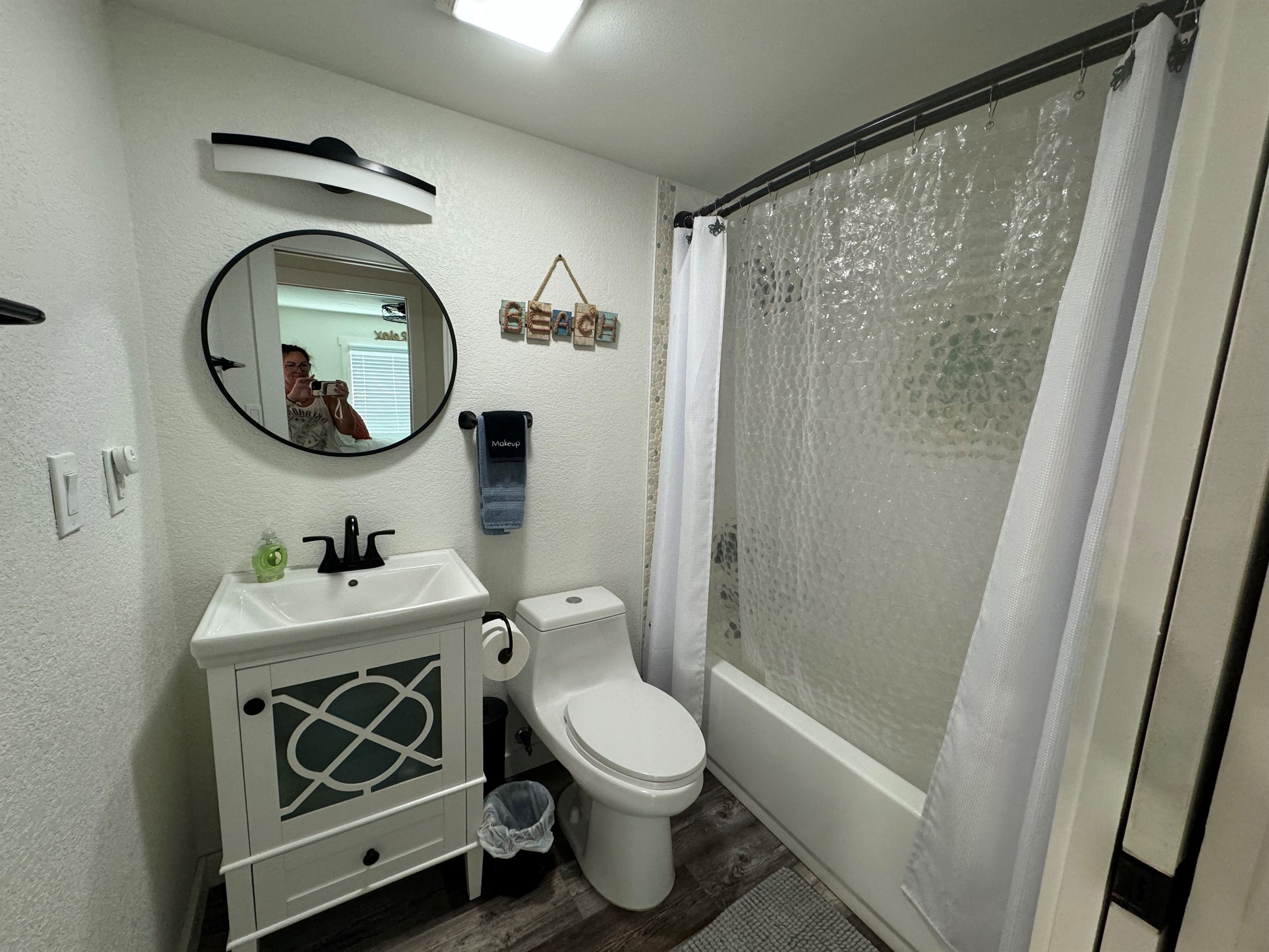 A bathroom with a toilet, sink, and shower curtain.