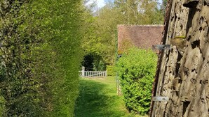 A pathway leading to a building with a stone wall and a red metal railing. - Pretty country house with large garden (Diges)