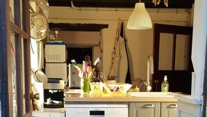 A compact kitchen with a dishwasher, a sink, and a hanging light fixture. - Pretty country house with large garden (Diges)