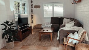 Ein Wohnzimmer mit Fernseher, Sofa und Couchtisch.