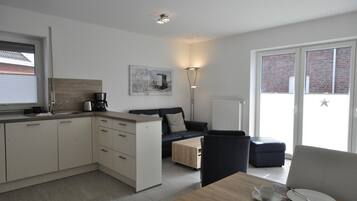 Eine moderne Küche mit Essbereich, einer Couch und einer Kaffeemaschine.
