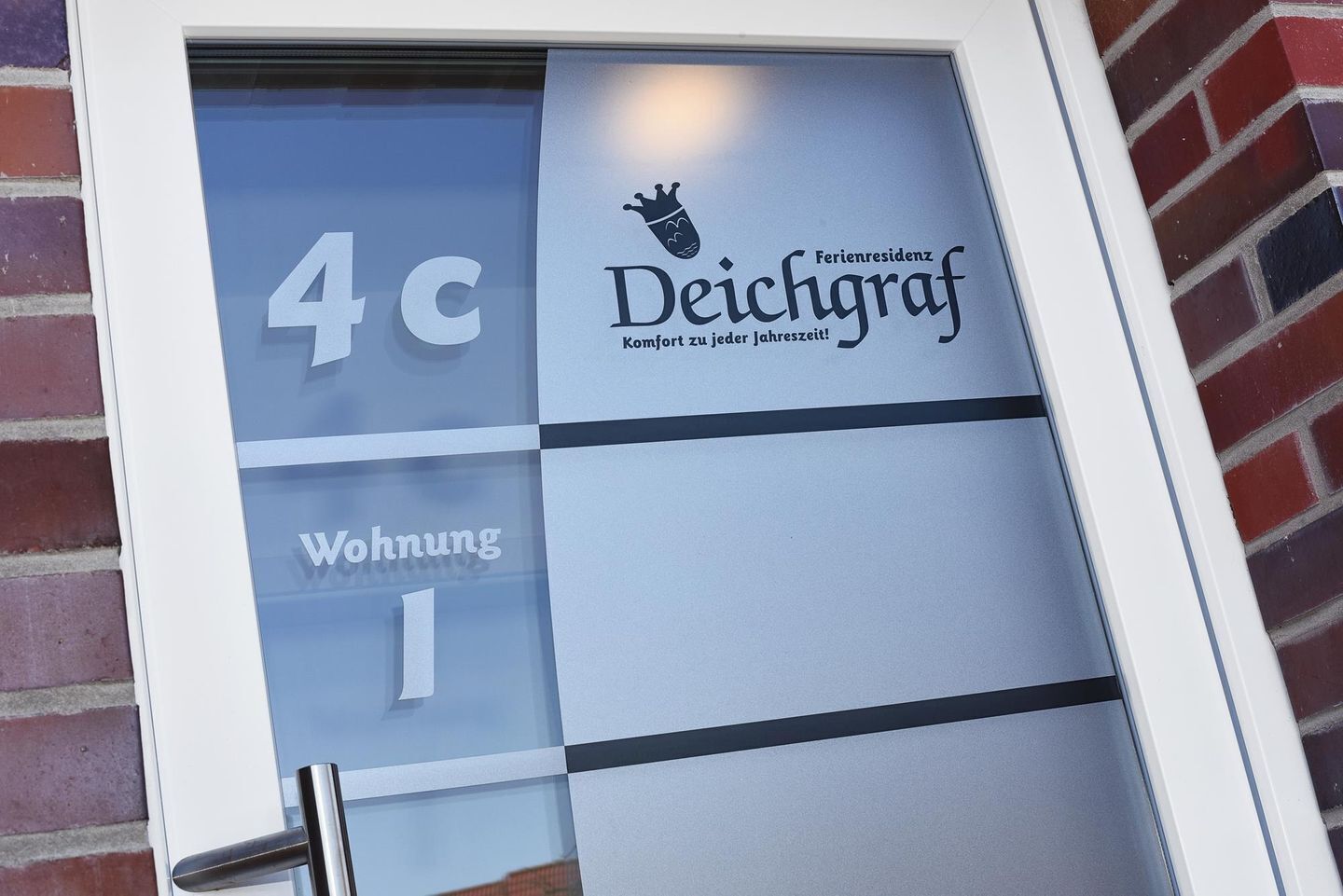 Ein Hotel Eingang mit Glastür, auf der die Nummer 4c und der Name 'Deichgraf' stehen.
