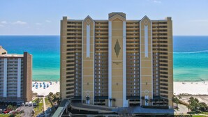 Un hôtel de grande hauteur doté de nombreux balcons, offrant une vue sur la plage et disposant d’un parking.