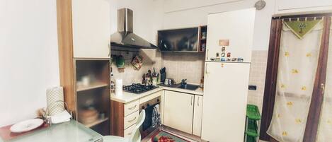 A compact kitchen with a stove, sink, and cabinets.
