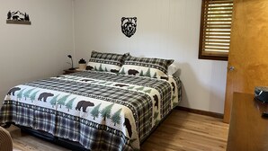 A bedroom with a bed, a nightstand, a lamp, and a door with blinds. - Mamaws mountain view Quiet country setting in the middle of a lot of attractions (Fletcher)