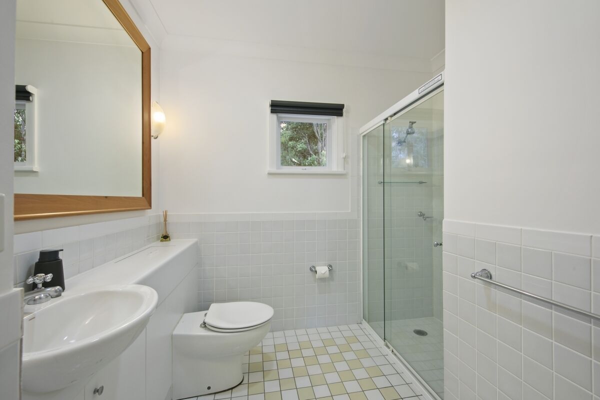 Ein Badezimmer mit Waschbecken, Toilette und einer Duschkabine aus Glas.