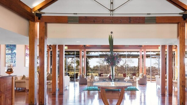 A spacious lobby with wooden beams, a central round table, and a large window offering a view of the outdoors. - 2 Bedroom Villa at Cypress Lakes Resort (Pokolbin)