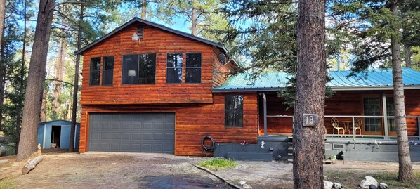 A log cabin with a garage, a small shed, and a patio area with outdoor furniture. - Your going to fall in love with this cabin.outstanding for family,multi families (Alpine)