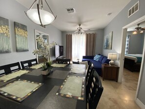 Relax in this stylish living space with a dining area, comfortable sofa, and large dining table.