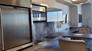 A modern kitchen with stainless steel appliances, a built-in oven, and a large sink.