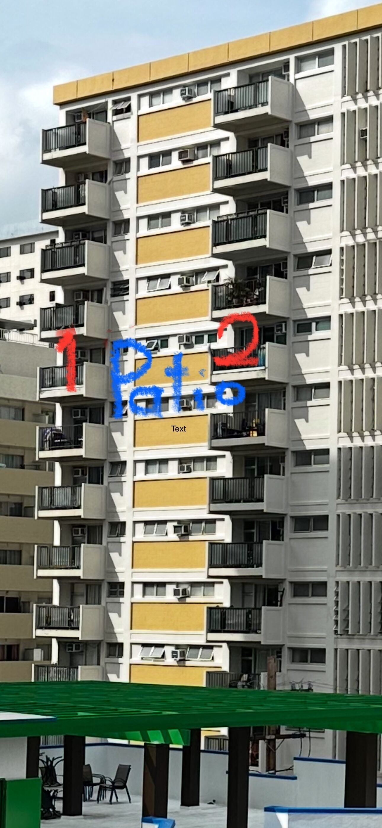 Um edifício residencial com várias andares, varandas, aparelhos de ar condicionado e um jardim no telhado verde.