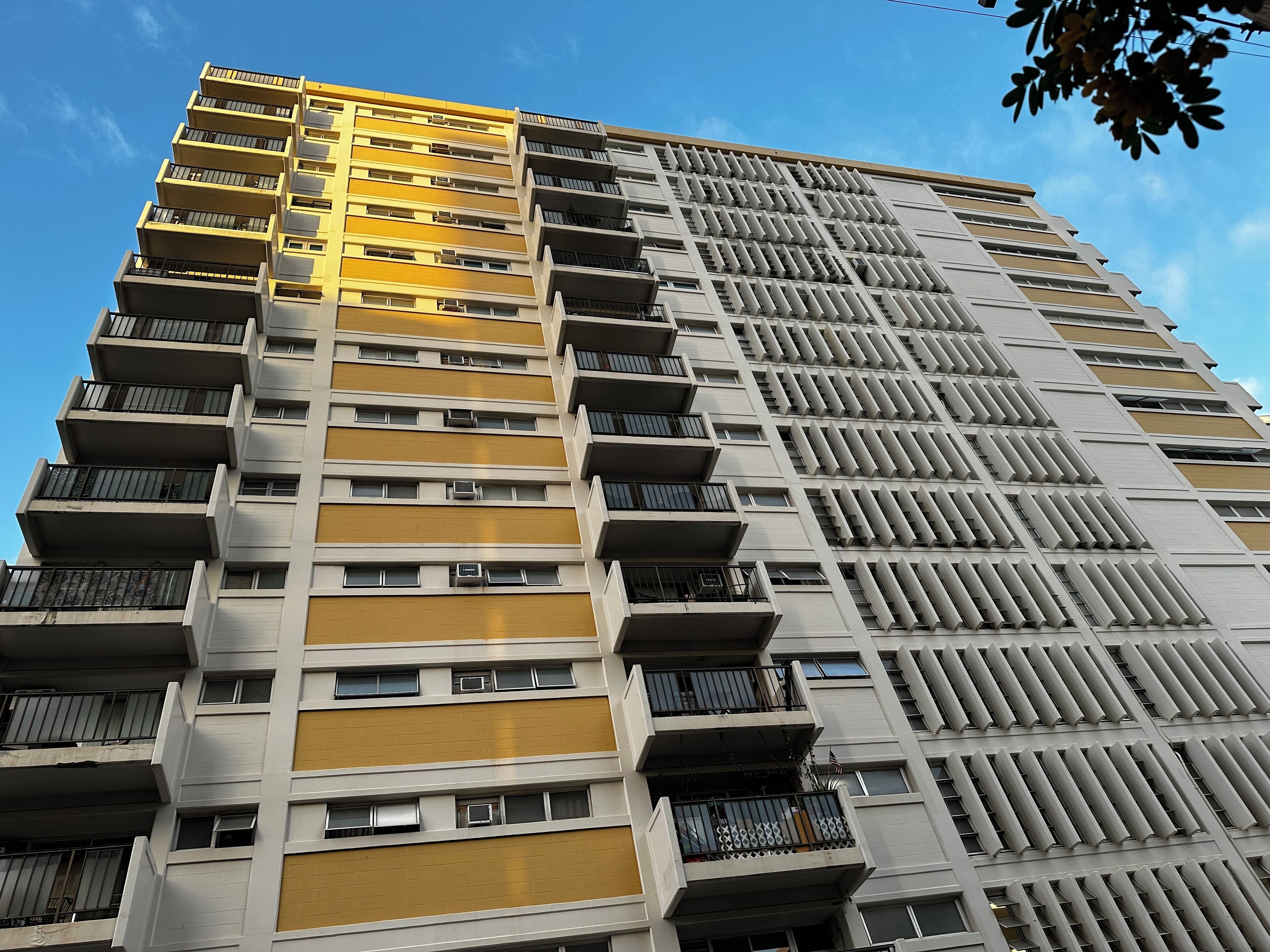 Un immeuble de grande hauteur doté de nombreux balcons et de plusieurs unités de climatisation.