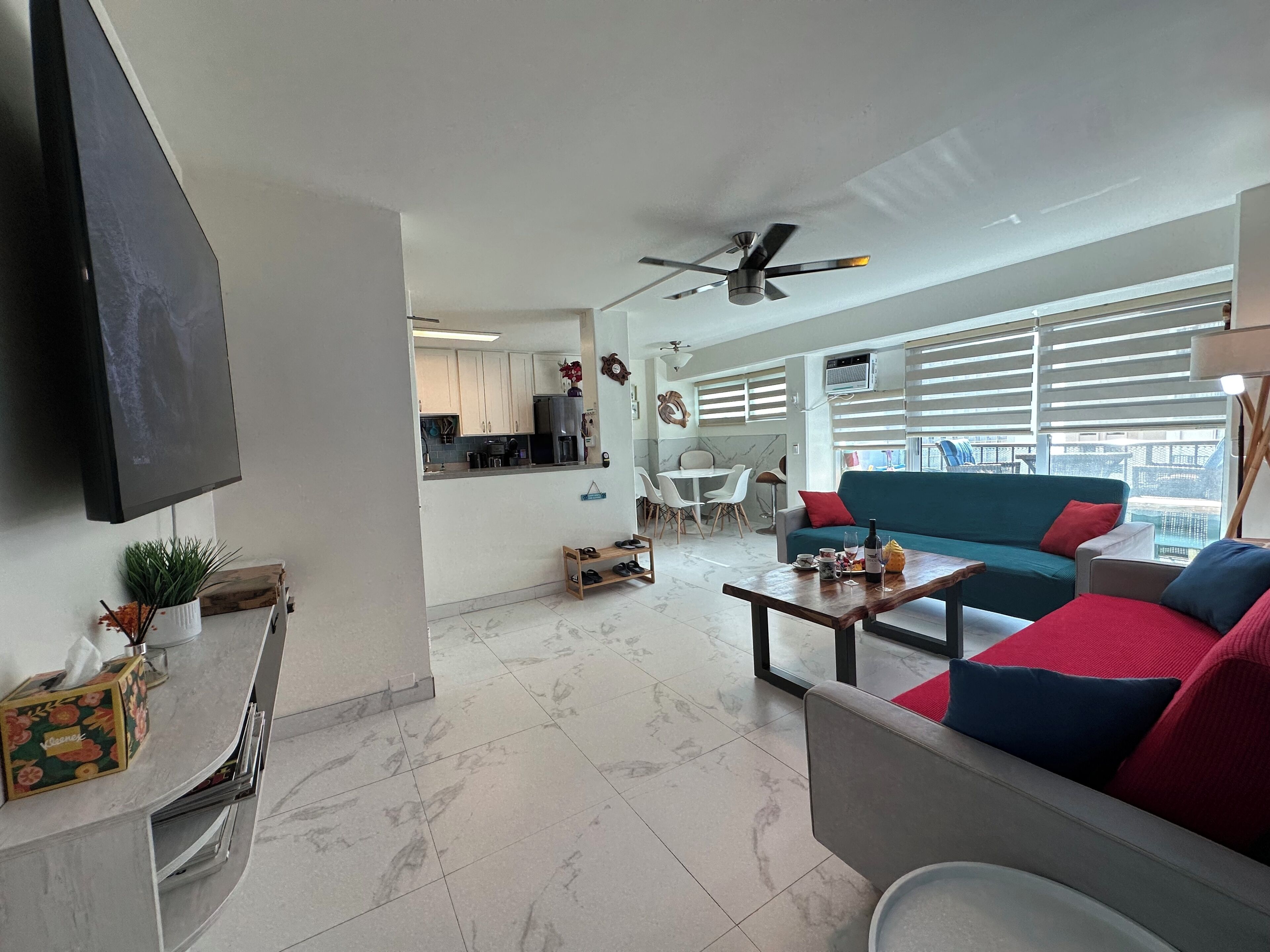 A modern living room with a sofa, coffee table, and a TV mounted on the wall.