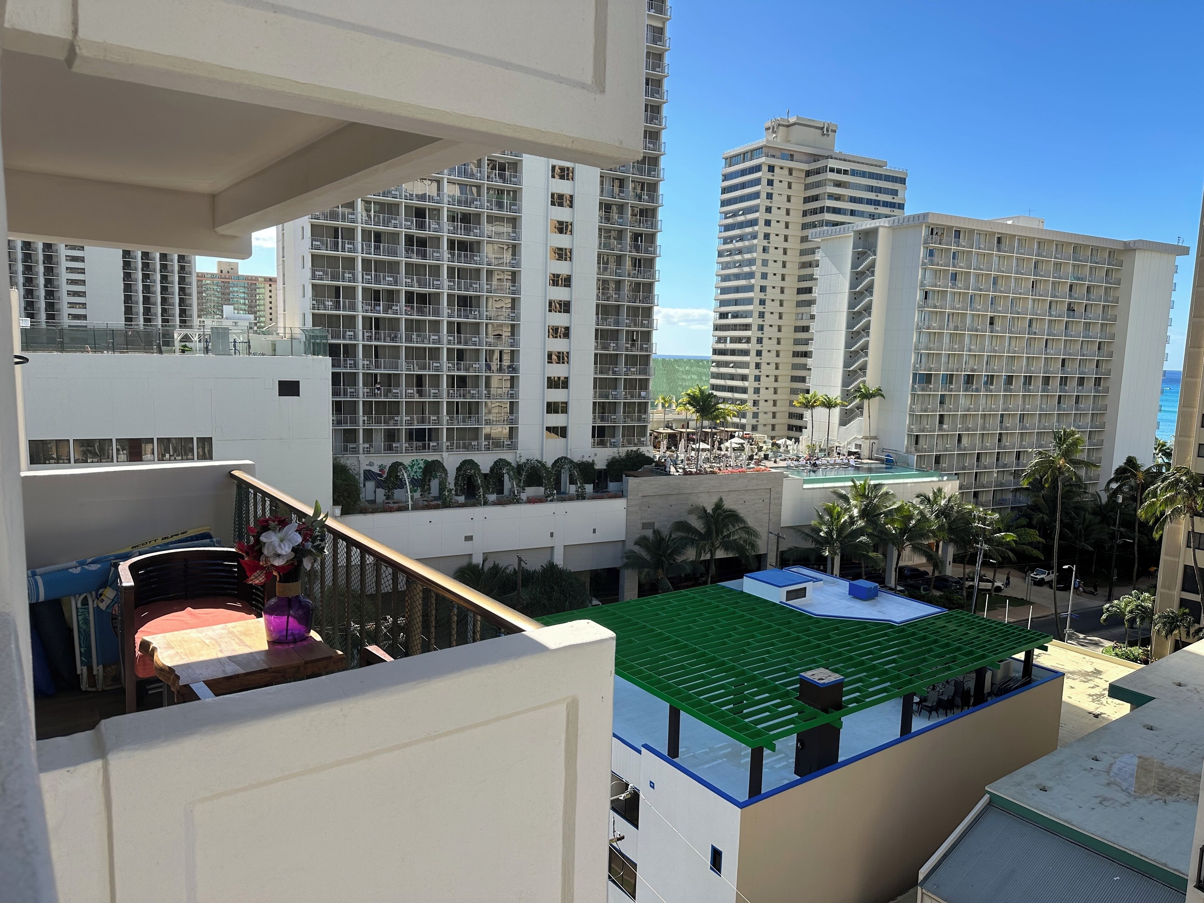 Un hotel di grattacielo con numerosi balconi, una zona piscina sul tetto e vista sull'oceano.