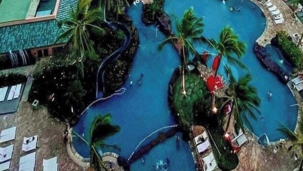 Een resort met een groot zwembad, een strand en uitzicht op de oceaan.