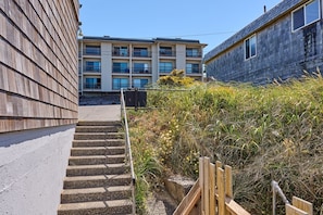 Stunning multi-story building with large windows and a flat roof, situated near a charming adjacent structure.