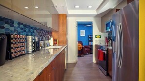 A modern kitchen with a marble countertop, stainless steel appliances, and a blue-tiled backsplash. - Stylish 2BR+Office, Big Pool, Pickleball and more (Palm Springs)