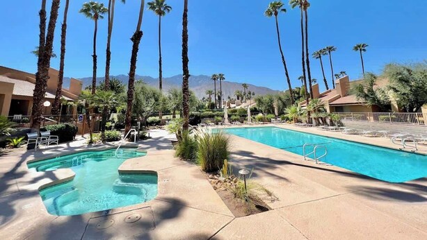 A pool area with multiple pools, palm trees, and a mountainous backdrop. - Stylish 2BR+Office, Big Pool, Pickleball and more (Palm Springs)