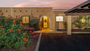 A building with a brick facade, a central arched entrance, and a covered porch area.