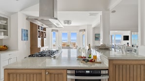 A spacious kitchen with a large island, modern appliances, and a view to the outside. - 1001 E. Arctic - Out Of The Blue - Unique Outdoor Space- Luxury (Folly Beach)